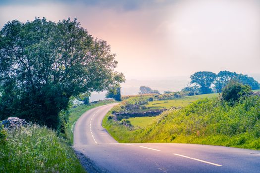 curved road in middle of rural Engalnd with dry stone walls