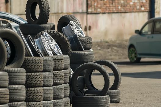 car tires with wheels laid on the street for sale in the industrial area near the garages