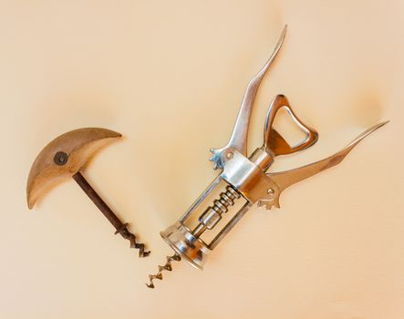 two corkscrews from different eras, one in metal and the other in wood and iron