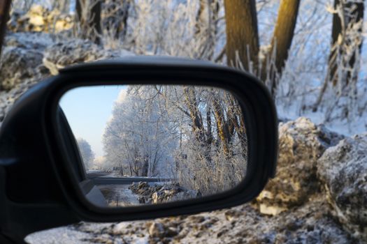 the reflection in the mirror of the car on a snowy highway