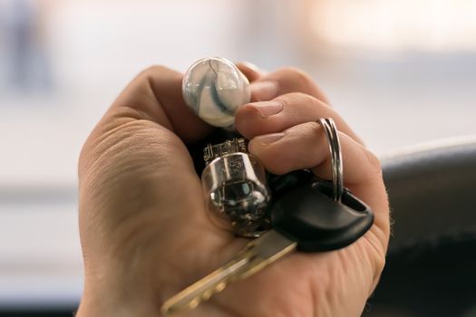 new and burnt out car light bulb, in man's hand