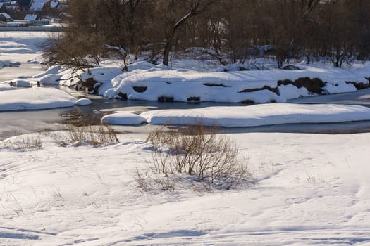 river on a sunny winter day partially covered with ice