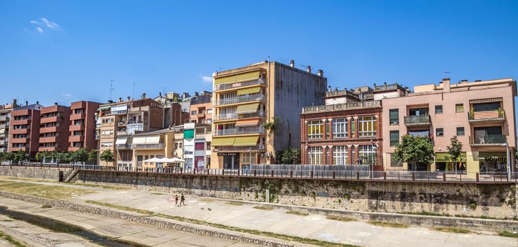 GIRONA, SPAIN - JULY 6, 2016: Modern architecture along the waterfront in Girona, Catalonia, Spain

Girona, Spain - July 6, 2016: Modern architecture along the waterfront in Girona, Catalonia, Spain. People are walking by street.