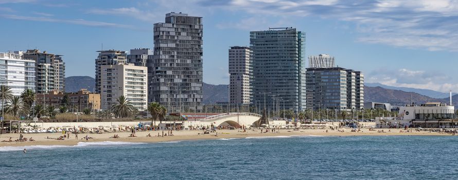 BARCELONA, SPAIN - JULY 13, 2016: Beach and New buildings at Sant Marti district, Barcelona, Spain

Barcelona, Spain - July 13, 2016: Beach and New buildings at Sant Marti district, Barcelona, Spain. People are resting on the beach.