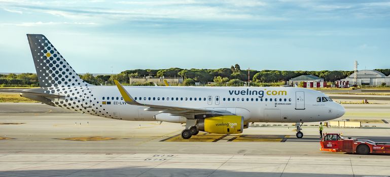 BARCELONA, SPAIN - JULY 14, 2016: Aircraft of Vueling Airlines at the gate in Terminal T1 of El Prat-Barcelona airport.

Barcelona, Spain - July 14, 2016: Aircraft of Vueling Airlines at the gate in Terminal T1 of El Prat-Barcelona airport. This airport was inaugurated in 1963. Airport is one of the biggest in Europe and one of the busiest in the world.