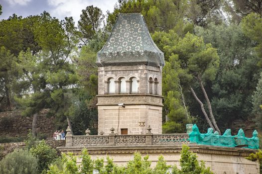 BARCELONA, SPAIN - JULY 3, 2016: Gaudi House Museum in Park Guell in Barcelona. It is a home where Antoni Gaudi, Spanish artist, lived and worked. 

Barcelona, Spain - July 3, 2016: Gaudi House Museum in Park Guell in Barcelona. It is a home where Antoni Gaudi, Spanish artist, lived and worked. People are walking by park.