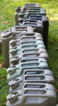 a row of WWII Jerry Cans in a field