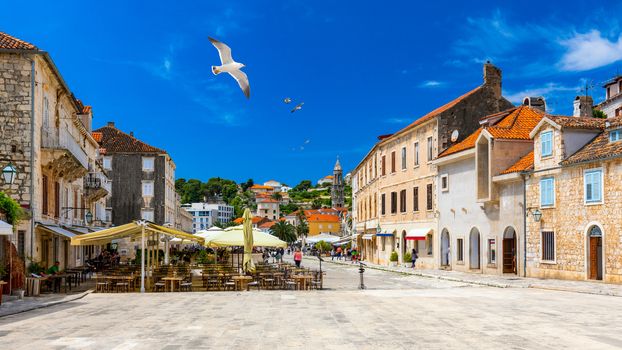 Main square in old medieval town Hvar with seagull's flying over. Hvar is one of most popular tourist destinations in Croatia in summer. Central Pjaca square of Hvar town, Dalmatia, Croatia. 