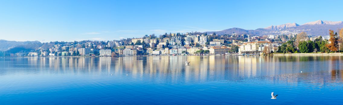LUGANO, SWITZERLAND - DECEMBER 29, 2015: Panoramic view of the lakeside promenade, with locals and visitors, in Lugano, Ticino, Switzerland