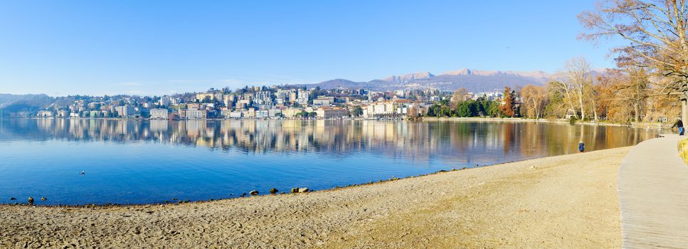 LUGANO, SWITZERLAND - DECEMBER 29, 2015: Panoramic view of the Parco Civico garden and the lakefront, with locals and visitors, in Lugano, Ticino, Switzerland