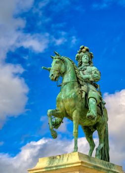 Versailles, France - April 24, 2019: Louis XIV statue just outside of the gates of Versailles Palace on a sunny day outside of Paris, France.