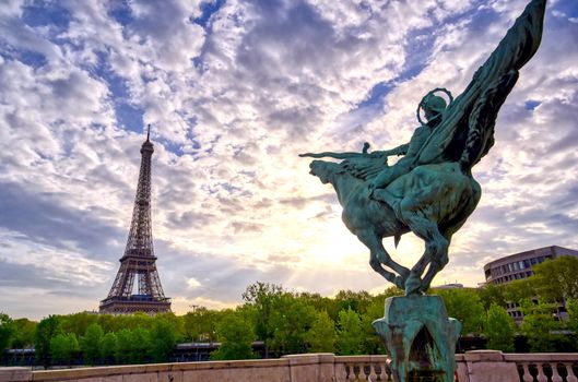 The Eiffel Tower across the Seine River in Paris, France on a sunny day with beautiful clouds.