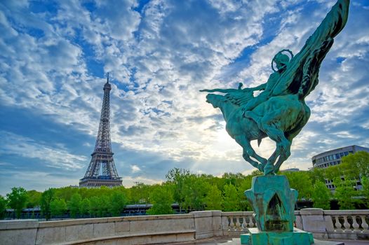 The Eiffel Tower across the Seine River in Paris, France on a sunny day with beautiful clouds.
