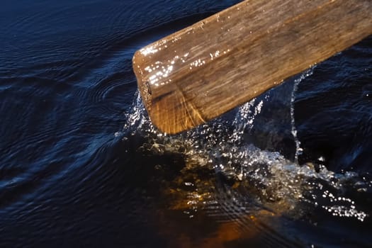 Paddle over the surface of the water. Rowing a paddle in the river.