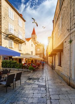 View at town Trogir, old touristic place in Croatia Europe with seagull's flying over city. Trogir town coastal view. Magnificent Trogir, Croatia. Sunny old Venetian town, Dalmatian Coast in Croatia.