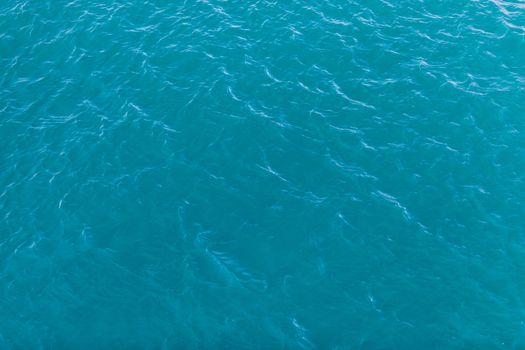 Background shot of aqua sea water surface. Sea surface aerial view. Waving water surface of the sea background.