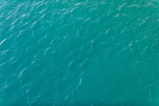 Background shot of aqua sea water surface. Sea surface aerial view. Waving water surface of the sea background.