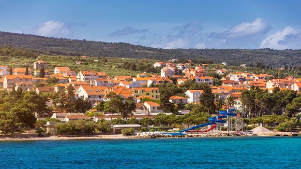 Supetar city in Brac island, Croatia. View from the sea. Picturesque scenic view on Supetar on Brac island, Croatia. Panoramic view on harbor of town Supetar from the side of sea. Brac, Croatia.