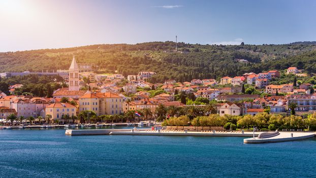 Supetar city in Brac island, Croatia. View from the sea. Picturesque scenic view on Supetar on Brac island, Croatia. Panoramic view on harbor of town Supetar from the side of sea. Brac, Croatia.