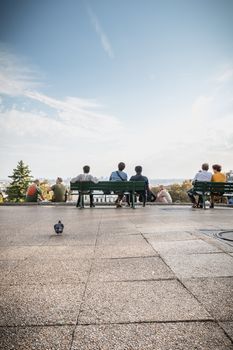 Paris, France - October 6, 2018: tourists seen from behind admire the view of Paris from the forecourt of the Sacre Coeur near Montmartre on a summer day