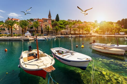 Splitska village with beautiful port and seagull's flying over the village, Brac island, Croatia. Fishing boats in Splitska village on Brac island seafront view, Dalmatia, Croatia, Croatia.