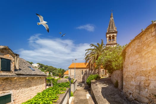 Splitska village with beautiful port and seagull's flying over the village, Brac island, Croatia. Fishing boats in Splitska village on Brac island seafront view, Dalmatia, Croatia, Croatia.