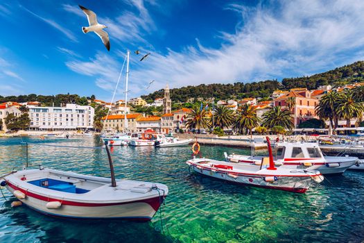 View at amazing archipelago with fishing boats in front of town Hvar, Croatia. Harbor of old Adriatic island town Hvar with seagull's flying over the city. Amazing Hvar city on Hvar island, Croatia. 