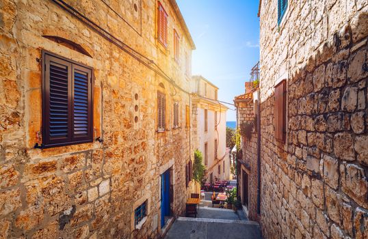 Beautiful street with flowers in the Hvar town, Hvar island, Dalmatia, Croatia. Old Mediterranean street, Hvar town. Old Adriatic town Hvar. Medieval street. Popular touristic destination of Croatia.