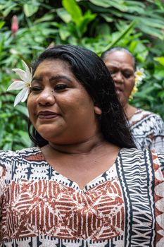 Kamokila Village, Kauai, Hawaii, USA. - January 16, 2020: Closeup of  female folk singer performing wedding song on stage in front of Fern Grotto. Green background.