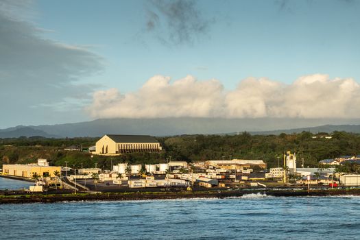 Nawiliwili, Kauai, Hawaii, USA. - January 16, 2020: Early morning light on Matson container yard in port with large self-storage buidling on hill top under light blue cloudscape.