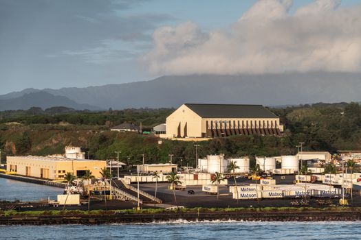 Nawiliwili, Kauai, Hawaii, USA. - January 16, 2020: Early morning light on Matson container yard in port with large self-storage buidling on hill top under light blue cloudscape.