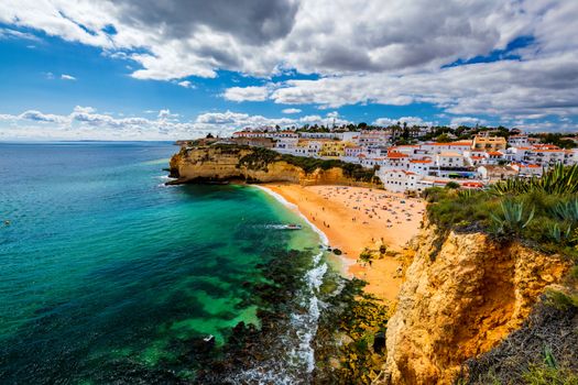 View of Carvoeiro fishing village with beautiful beach, Algarve, Portugal. View of beach in Carvoeiro town with colorful houses on coast of Portugal. The village Carvoeiro in the Algarve Portugal.