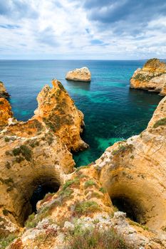 View of stunning beach with golden color rocks in Alvor town , Algarve, Portugal. View of cliff rocks on Alvor beach, Algarve region, Portugal.