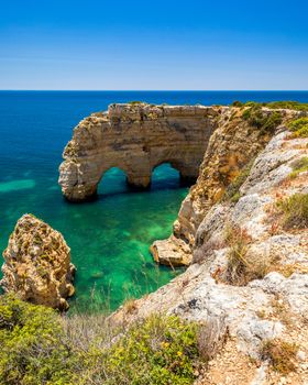 Natural caves at Marinha beach, Algarve Portugal. Rock cliff arches on Marinha beach and turquoise sea water on coast of Portugal in Algarve region. 