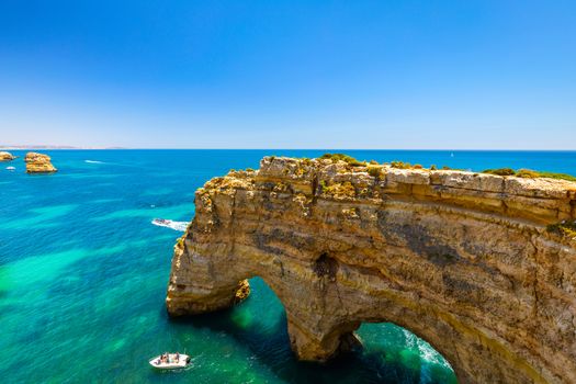 Natural caves at Marinha beach, Algarve Portugal. Rock cliff arches on Marinha beach and turquoise sea water on coast of Portugal in Algarve region. 