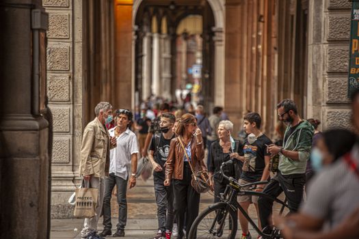 BOLOGNA, ITALY 17 JUNE 2020: People walking under arcades in Bologna, Italy
