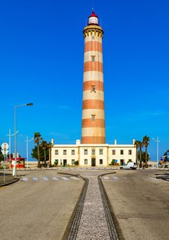 Lighthouse of Praia da Barra during the day, with a clear blue sky. View of the lighthouse of Barra beach (Praia da Barra) in Aveiro, Portugal. 