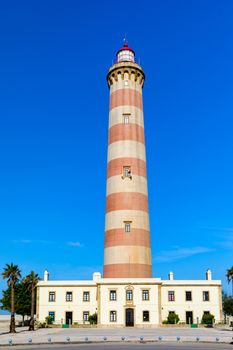 Lighthouse of Praia da Barra during the day, with a clear blue sky. View of the lighthouse of Barra beach (Praia da Barra) in Aveiro, Portugal. 
