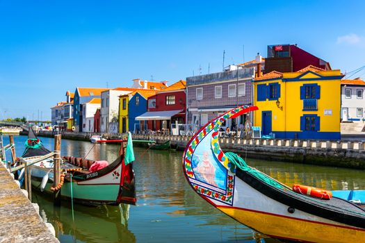 Traditional boats on the canal in Aveiro, Portugal. Colorful Moliceiro boat rides in Aveiro are popular with tourists to enjoy views of the charming canals. Aveiro, Portugal. 