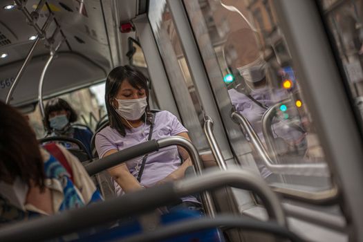 BOLOGNA, ITALY 17 JUNE 2020: Girl in the bus with medical mask during Covid quarantine