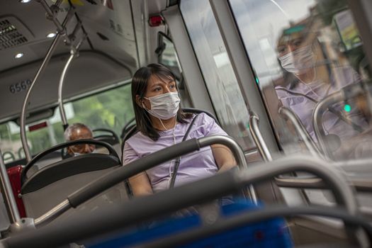 BOLOGNA, ITALY 17 JUNE 2020: Girl in the bus with medical mask during Covid quarantine