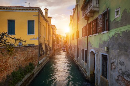 Street canal in Venice, Italy. Narrow canal among old colorful brick houses in Venice, Italy. Venice postcard