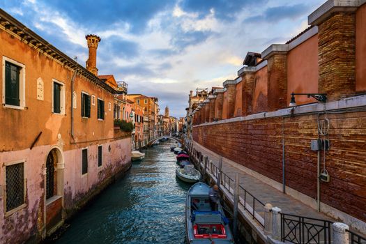Street canal in Venice, Italy. Narrow canal among old colorful brick houses in Venice, Italy. Venice postcard