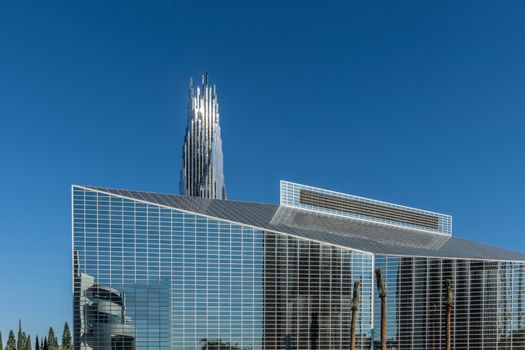 Garden Grove, California, USA - December 13, 2018: Crystal Christ Cathedral. Closeup of Church building and Crean Tower against blue sky. Cultural Center reflected in wall.