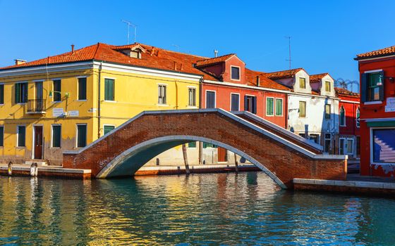 Murano glass making island, water canal, bridge, boat and traditional buildings. Venice or Venezia, Italy, Europe.