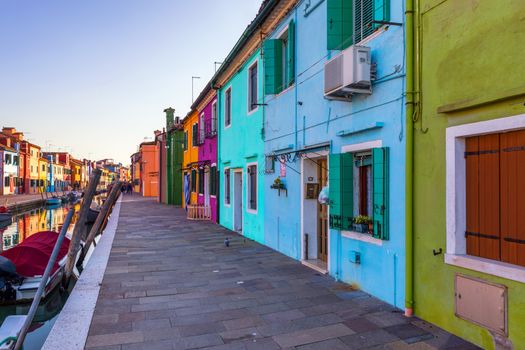Street with colorful buildings in Burano island, Venice, Italy. Architecture and landmarks of Burano, Venice postcard. Scenic canal and colorful architecture in Burano island near Venice, Italy