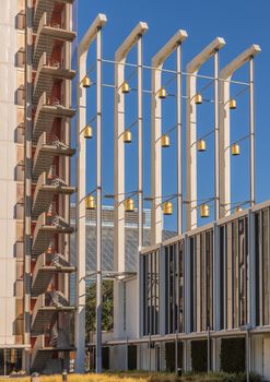 Garden Grove, California, USA - December 13, 2018: Crystal Christ Cathedral. Golden bell composition and part of Tower of Hope against blue sky. Walls and roofs of cathedral in back.