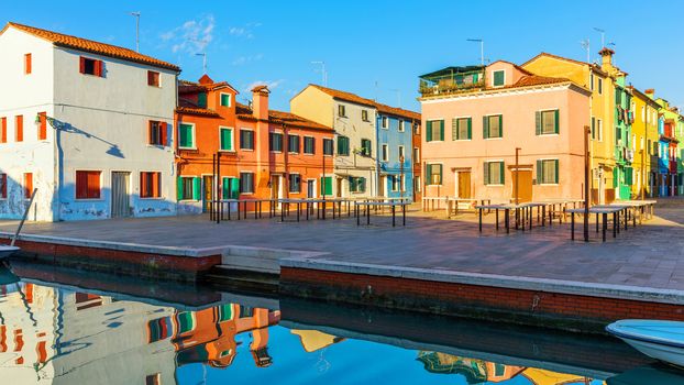 Beautiful view of the canals of Burano with boats and beautiful, colorful buildings. Burano village is famous for its colorful houses. Venice, Italy.