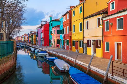 Beautiful view of the canals of Burano with boats and beautiful, colorful buildings. Burano village is famous for its colorful houses. Venice, Italy.