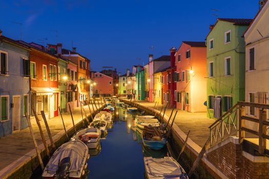 Street view with colorful buildings in Burano island at night, Venice, Italy. Architecture and landmarks of Burano, Venice postcard. Scenic canal and colorful architecture in Burano island near Venice, Italy